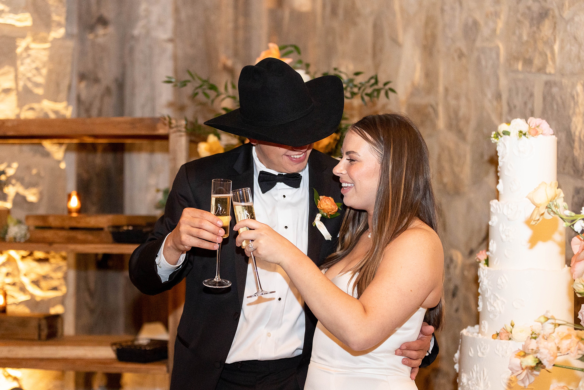 newlyweds toast champagne during wedding reception in the barn at the Hotel Drover