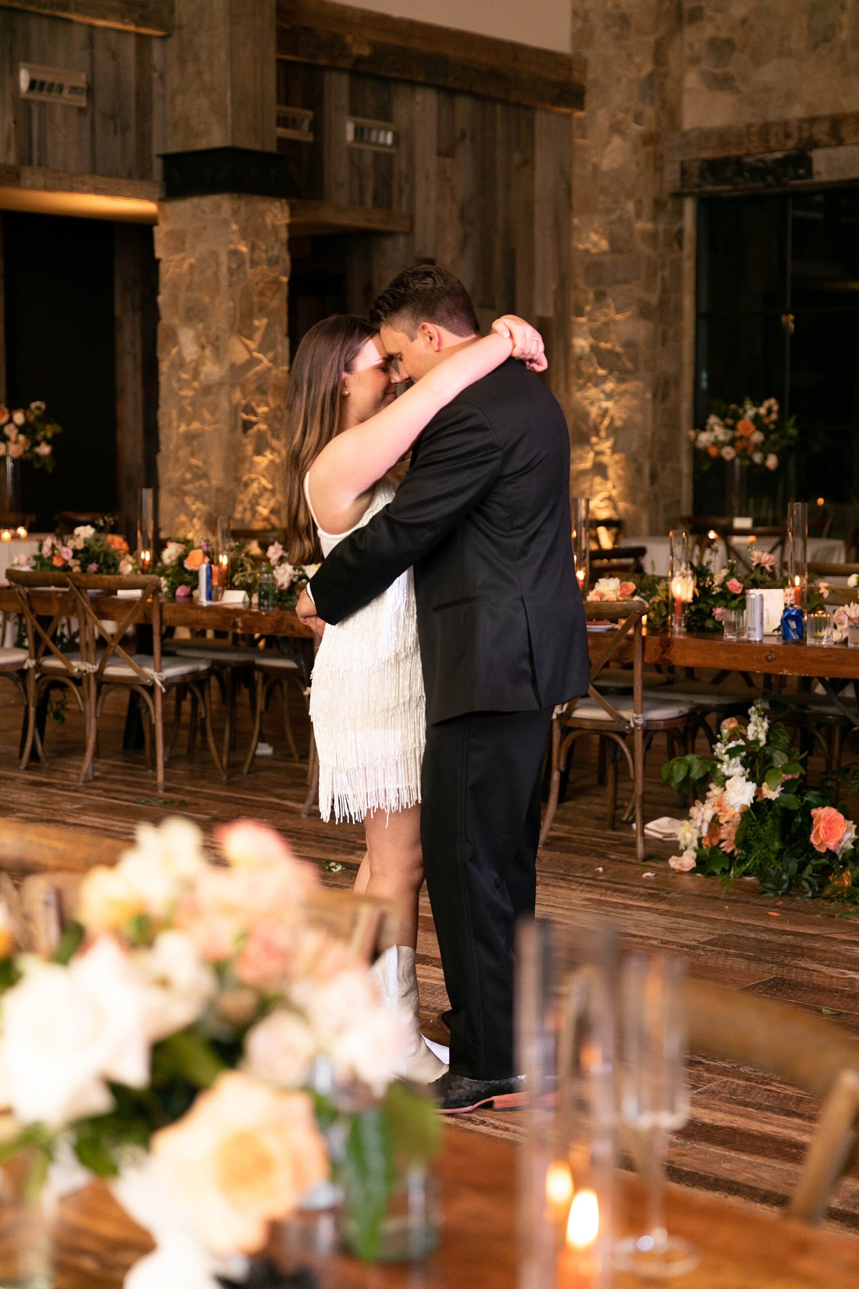 newlyweds hug close on dance floor 