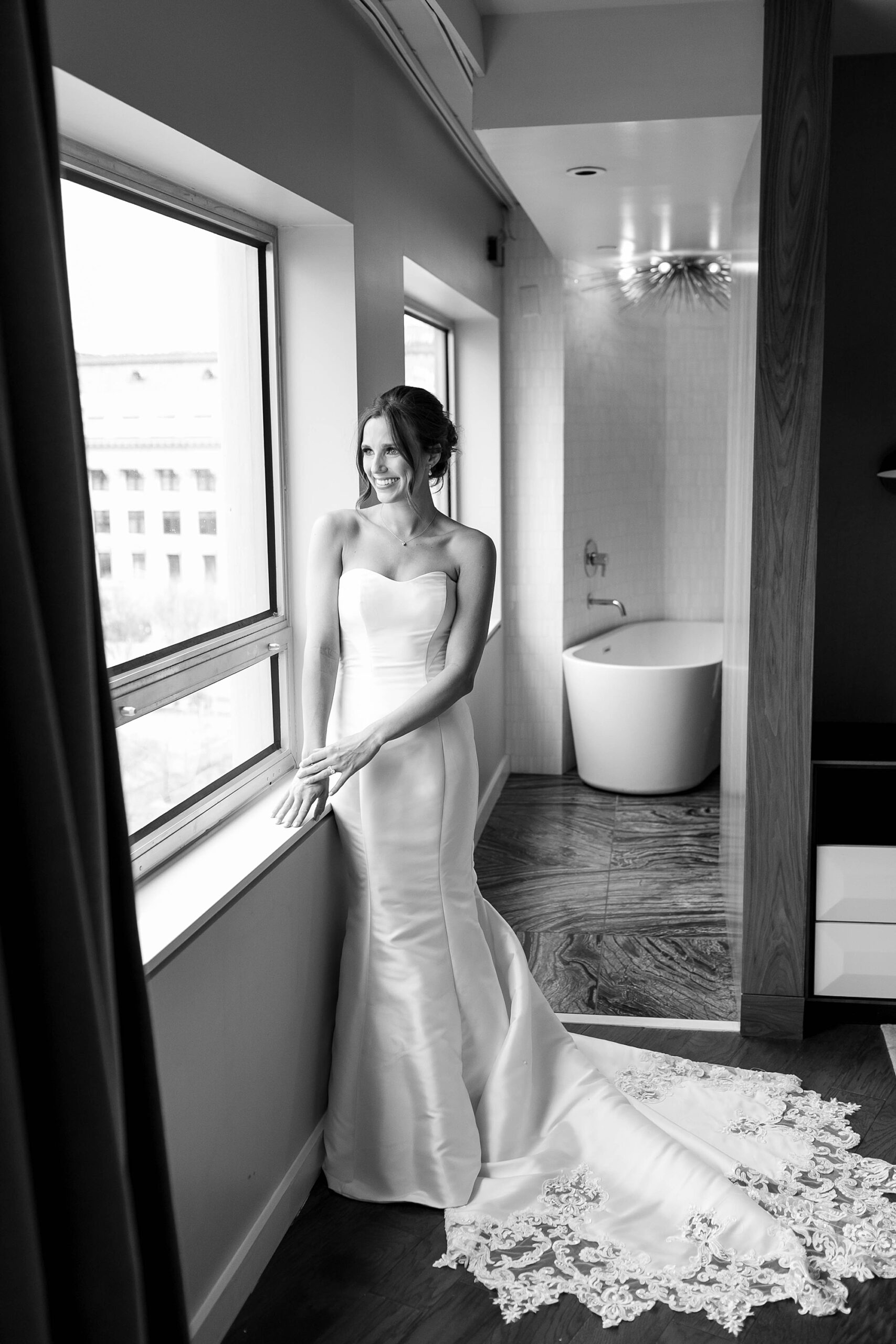 bride leans against window in wedding gown at the Statler Hotel