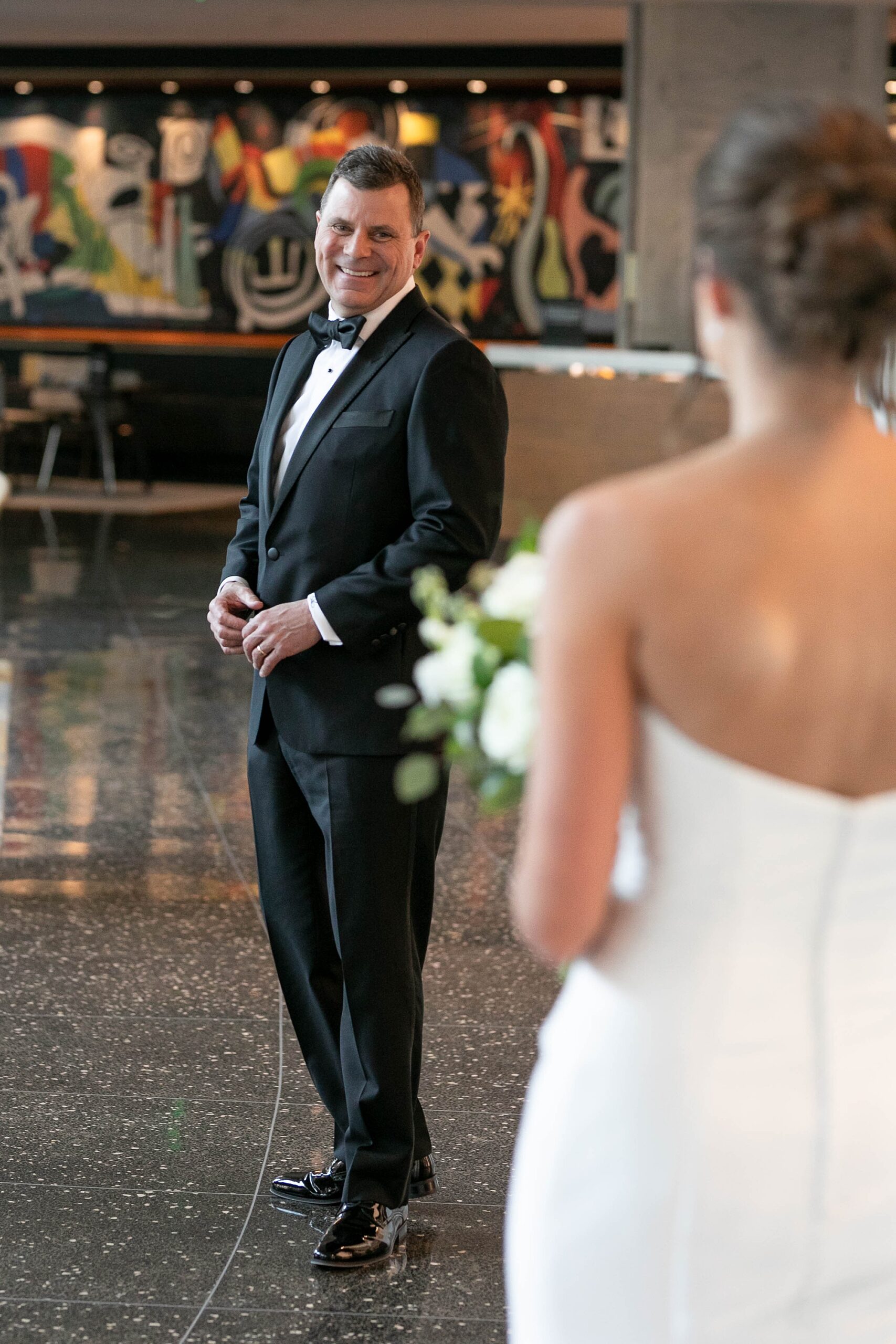 father turns to look at bride during first look in lobby of the Statler Hotel