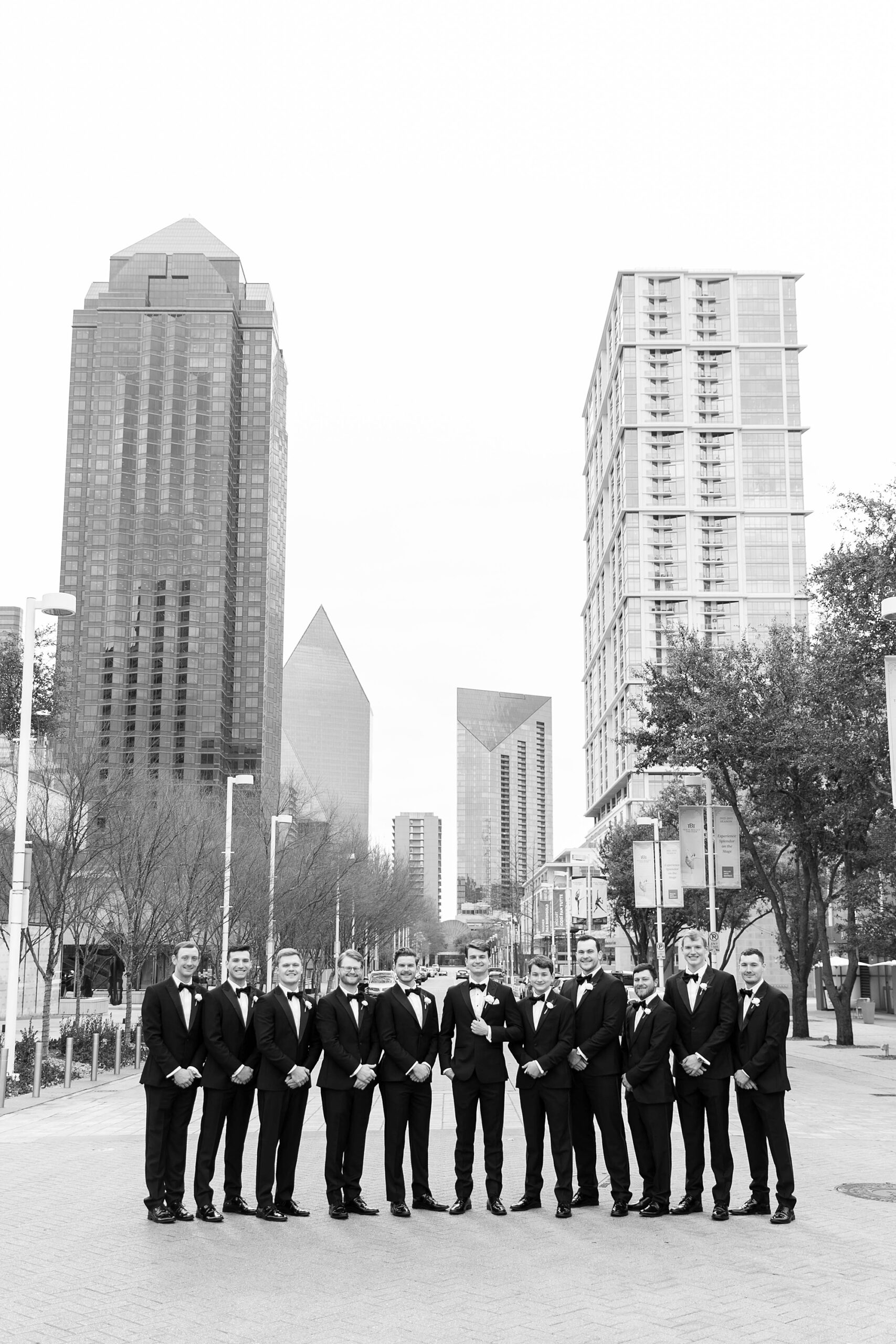 groom and groomsmen stand on Dallas street near the Statler Hotel
