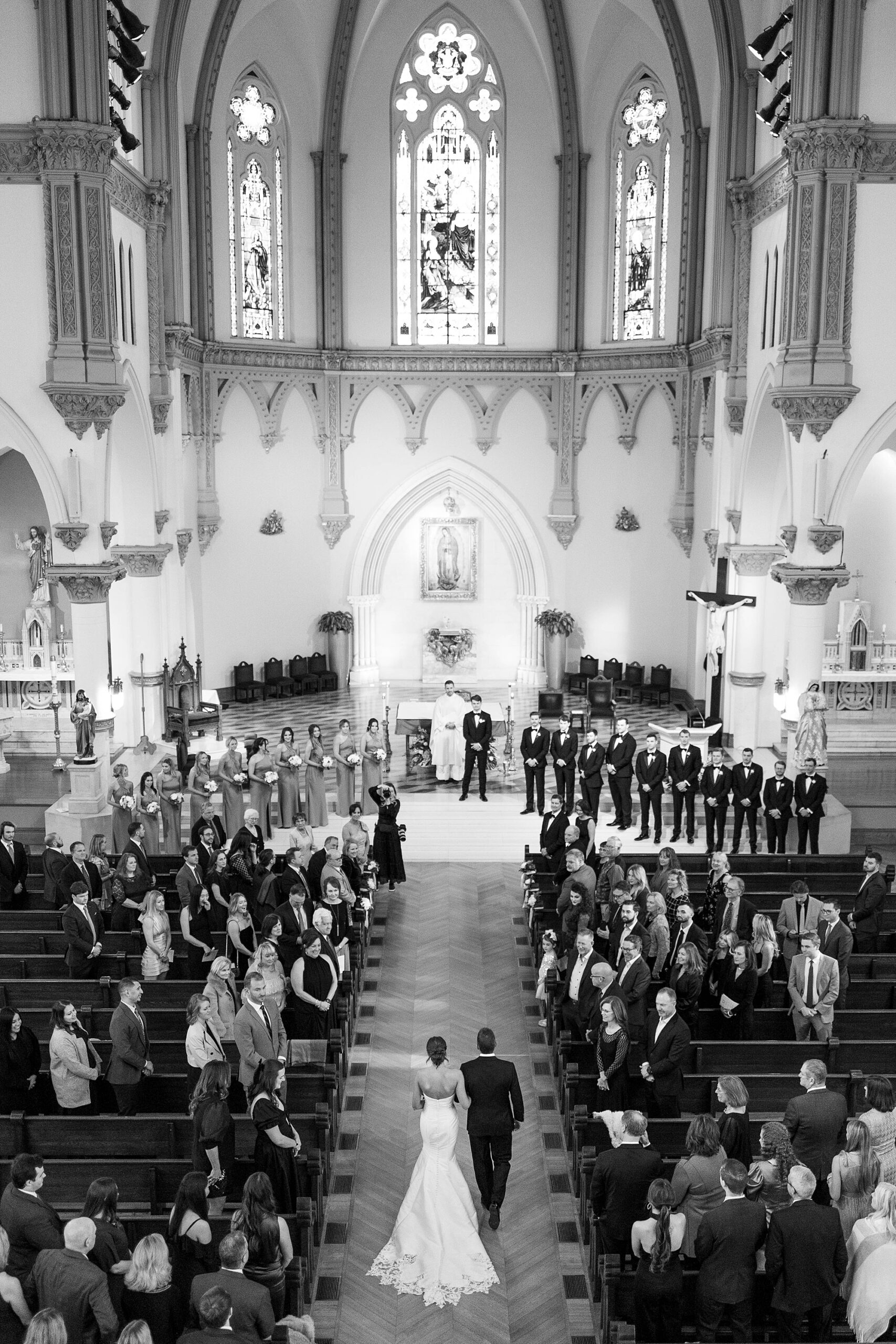 bride walks down aisle with father for traditional Catholic wedding at the Cathedral Guadalupe in Dallas TX