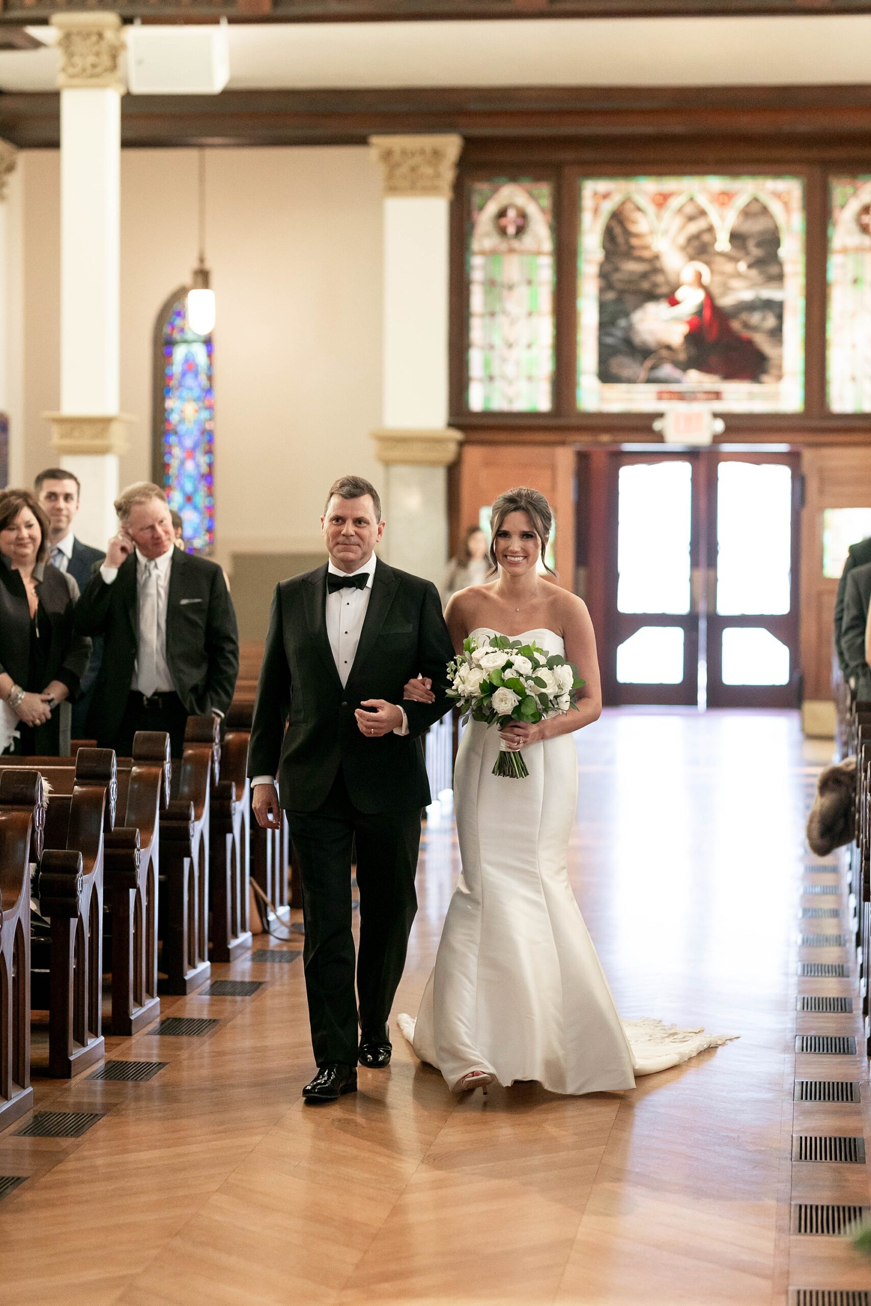 father escorts bride down aisle before traditional Catholic wedding at the Cathedral Guadalupe in Dallas TX