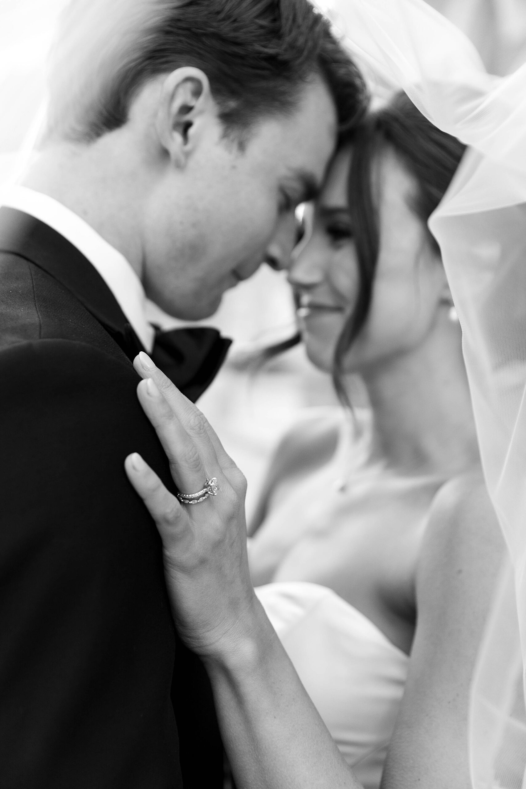 newlyweds hug while groom nuzzles forehead against bride