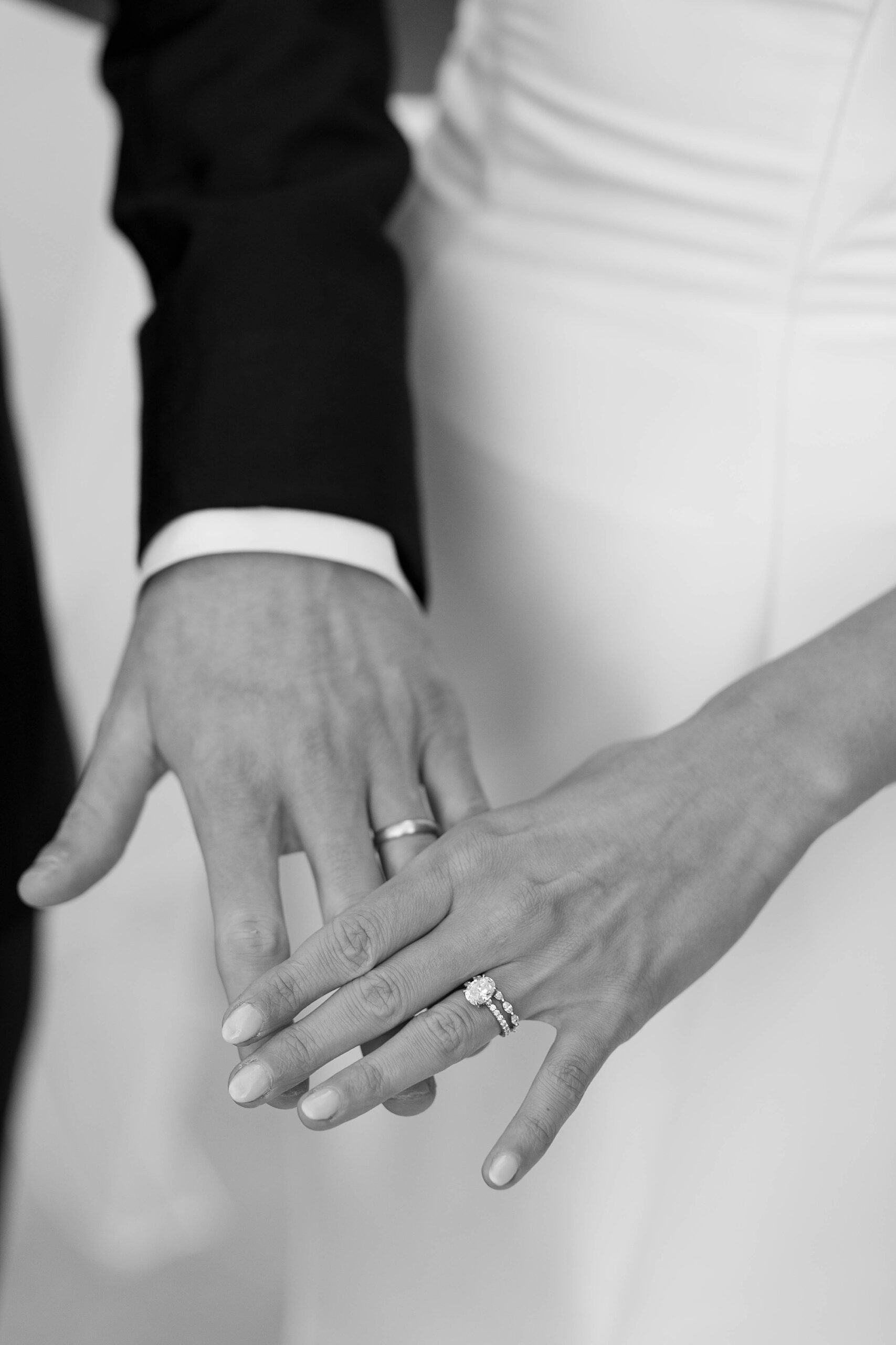 bride and groom hold hands out showing off wedding rings