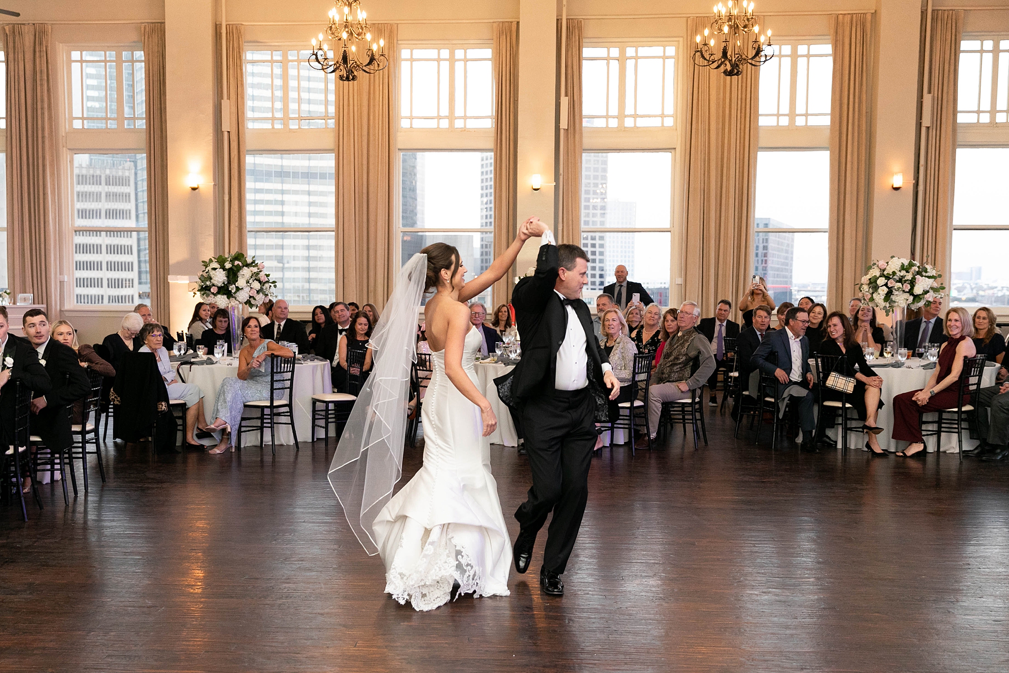 groom twirls bride under his arm during first dance at the Room on Main