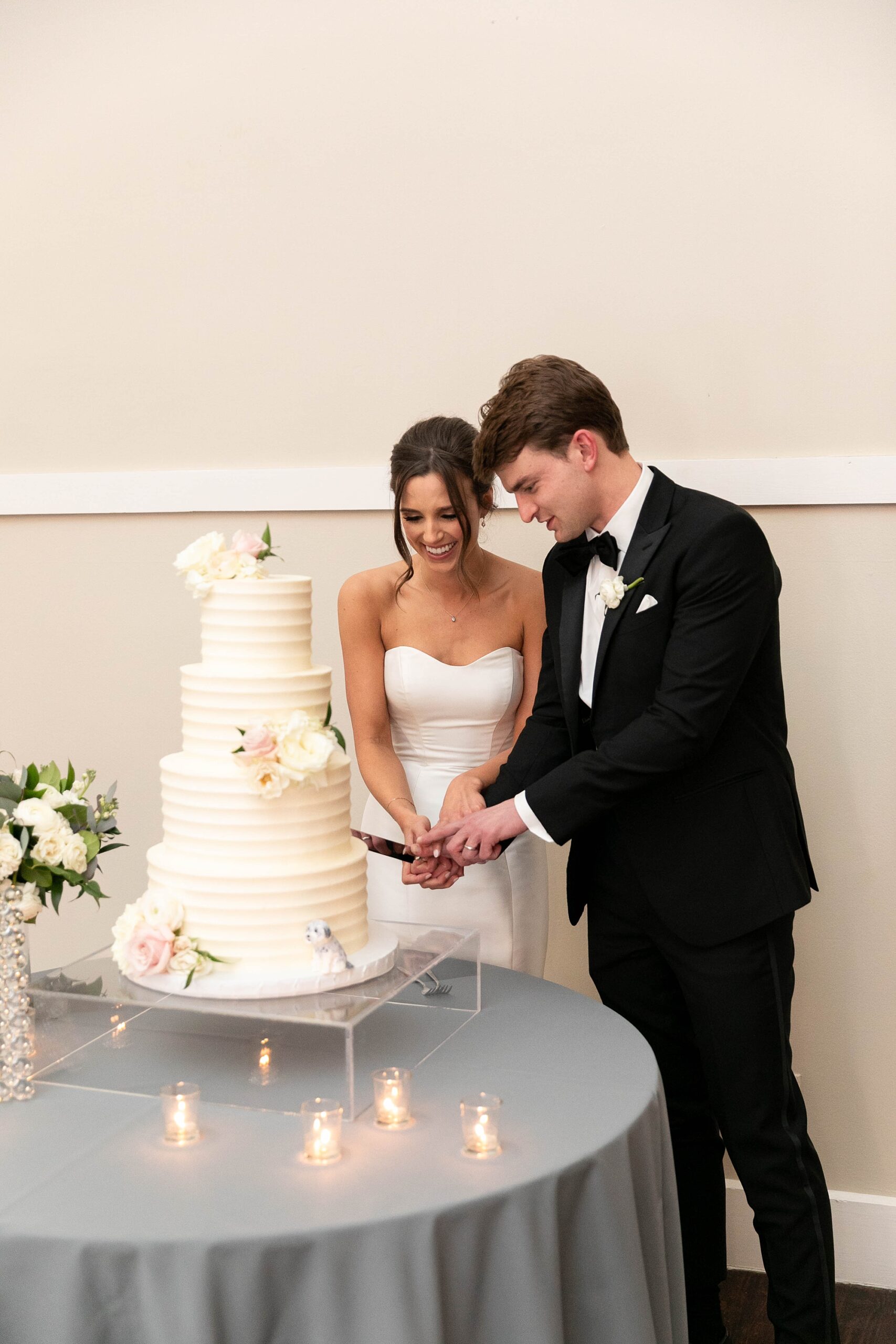 newlyweds cut wedding cake together during reception at the Room on Main