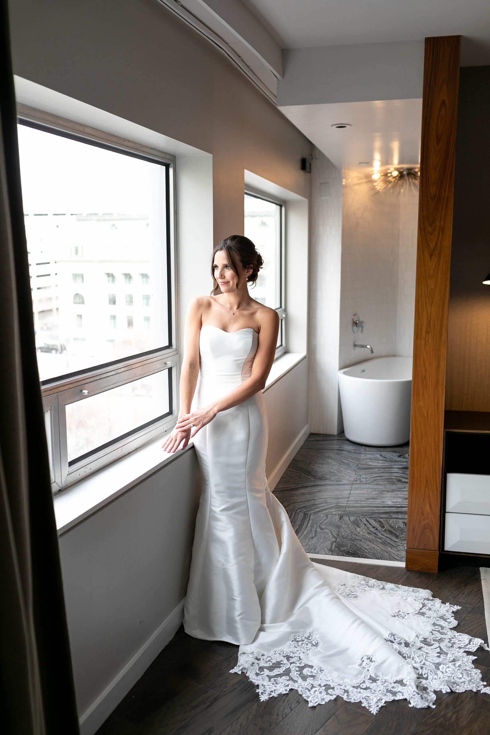 bride looks out window at Dallas at the Statler Hotel 