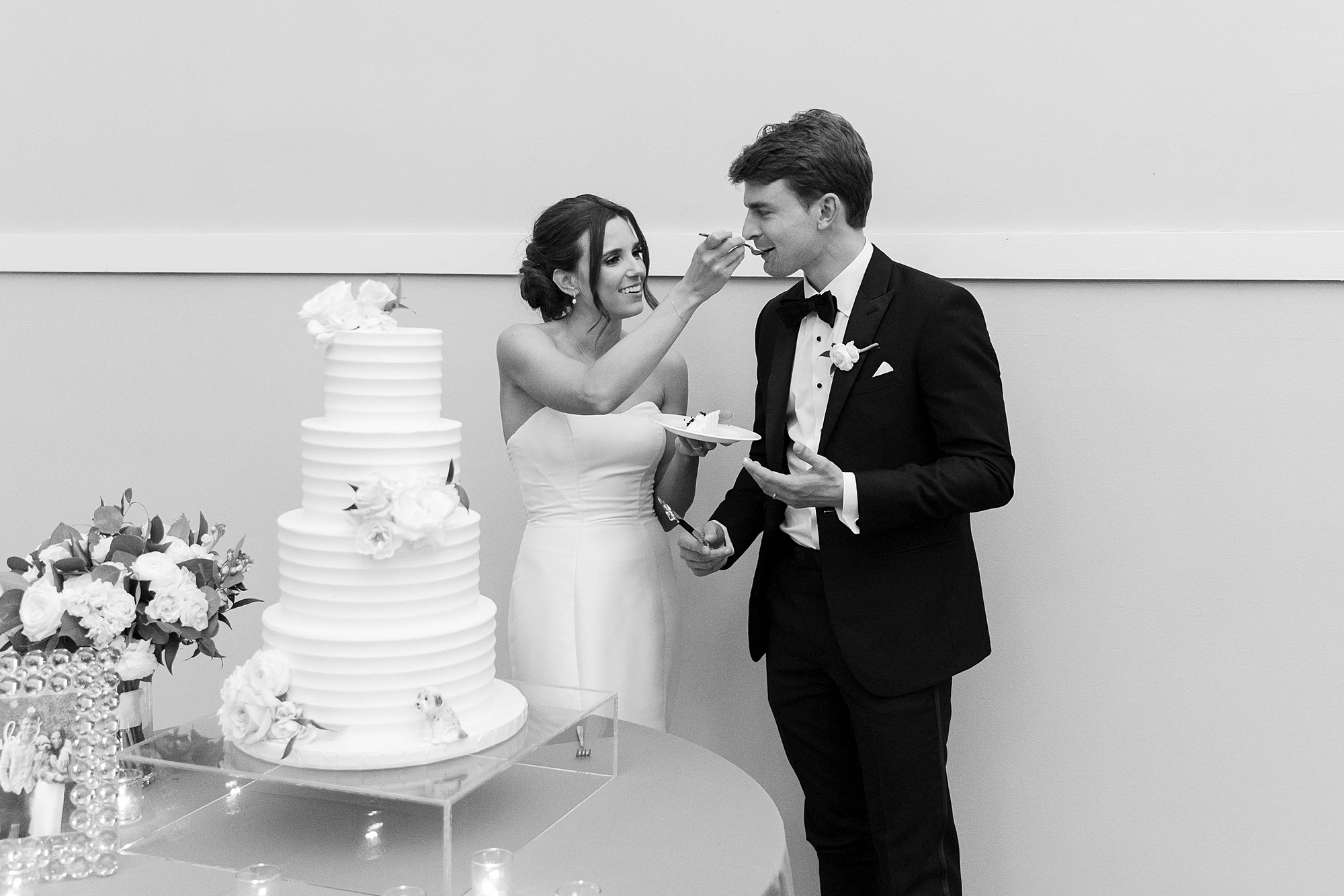 bride feeds groom cake during wedding reception at the Room on Main