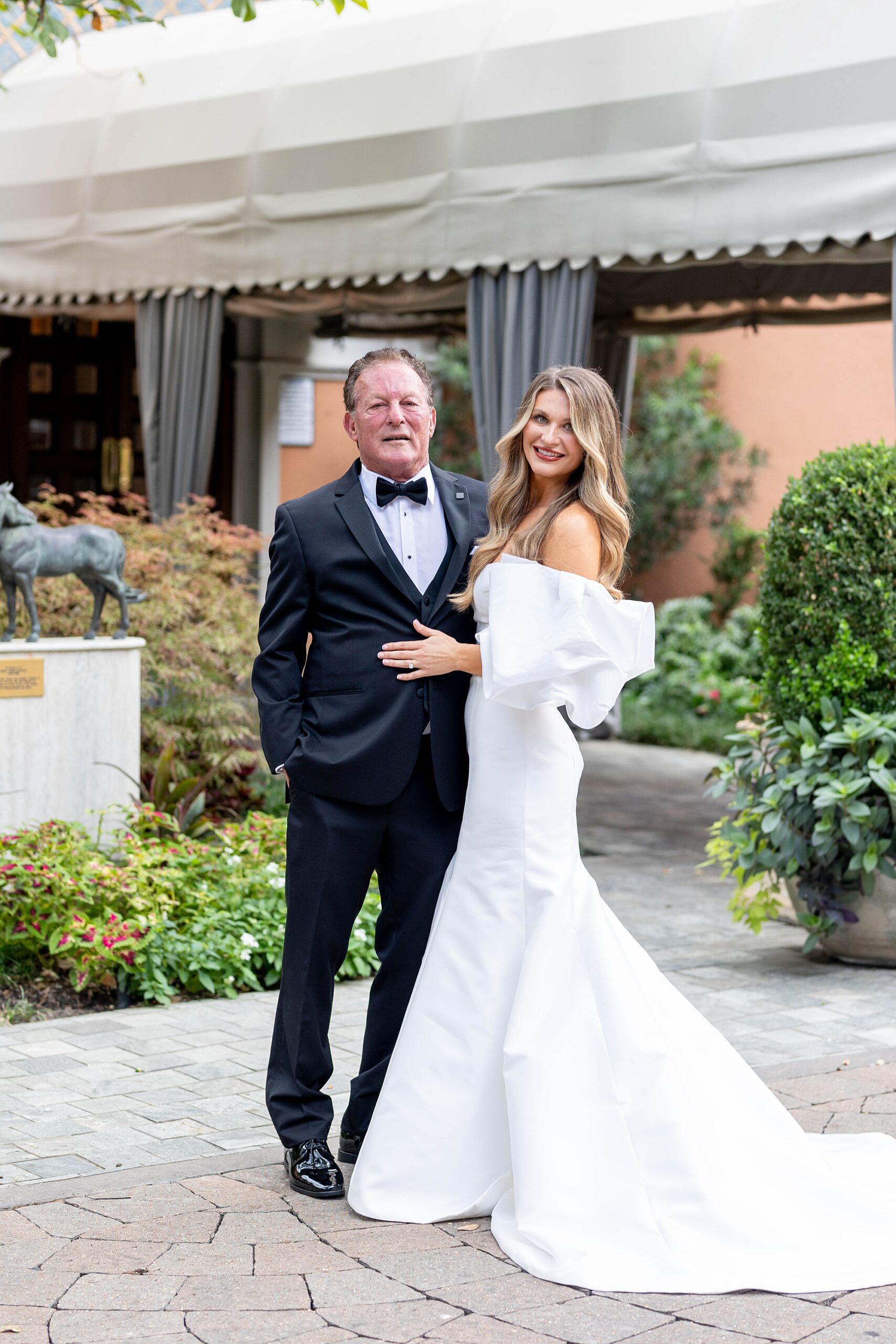 bride in off-the-shoulder wedding gown with puffy shoulders hugs dad