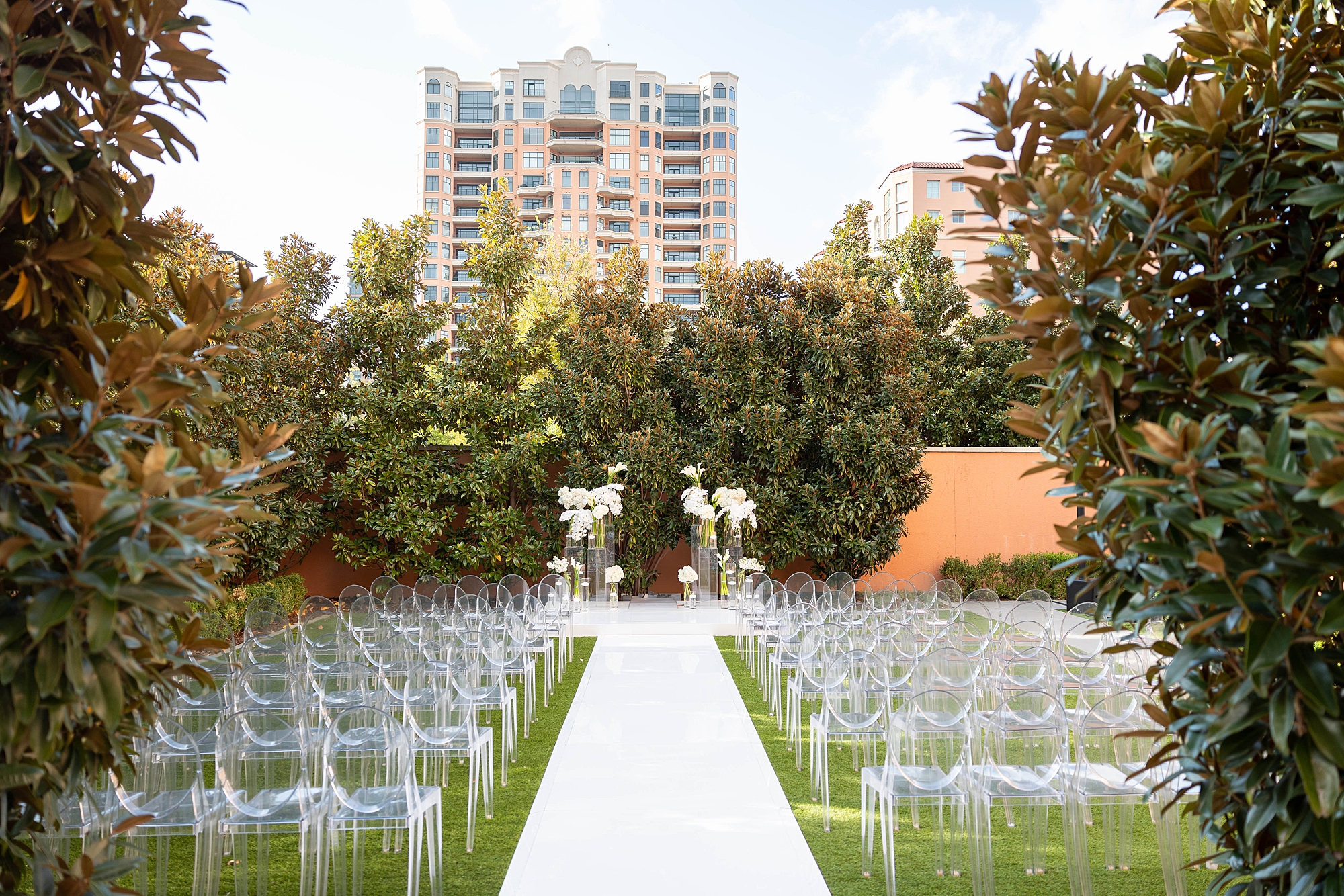 ceremony site on lawn at Rosewood Mansion with white chairs and white aisle in front of Dallas skyline