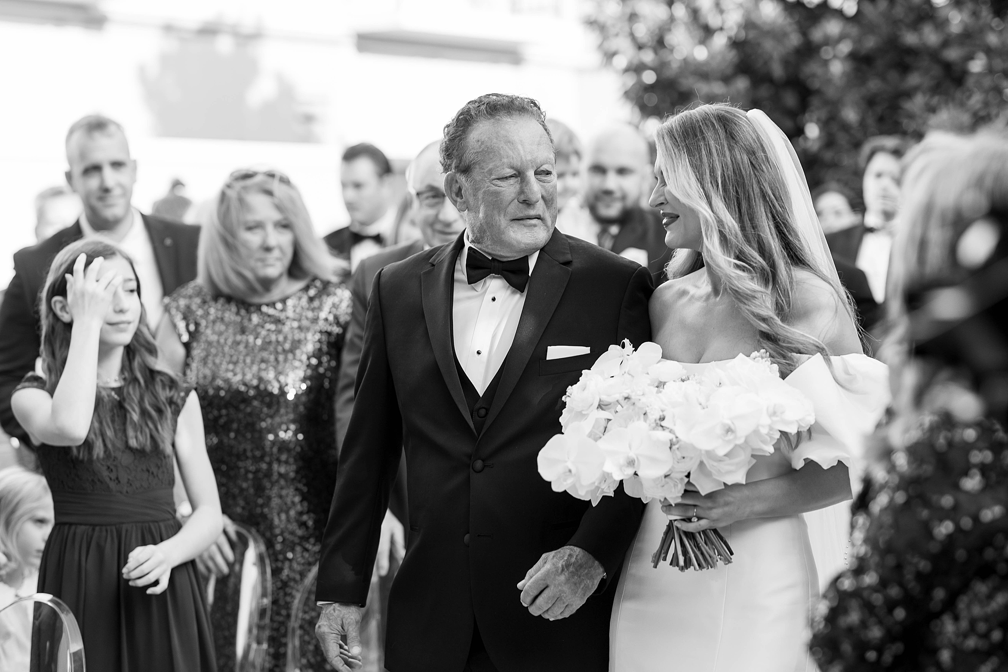 father in tux turns to look at bride during walk down aisle at Rosewood Mansion