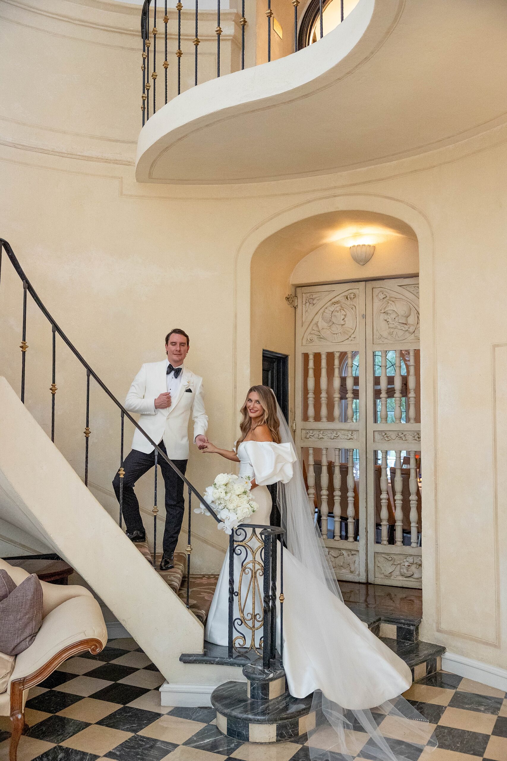 bride and groom stand on staircase inside Rosewood Mansion