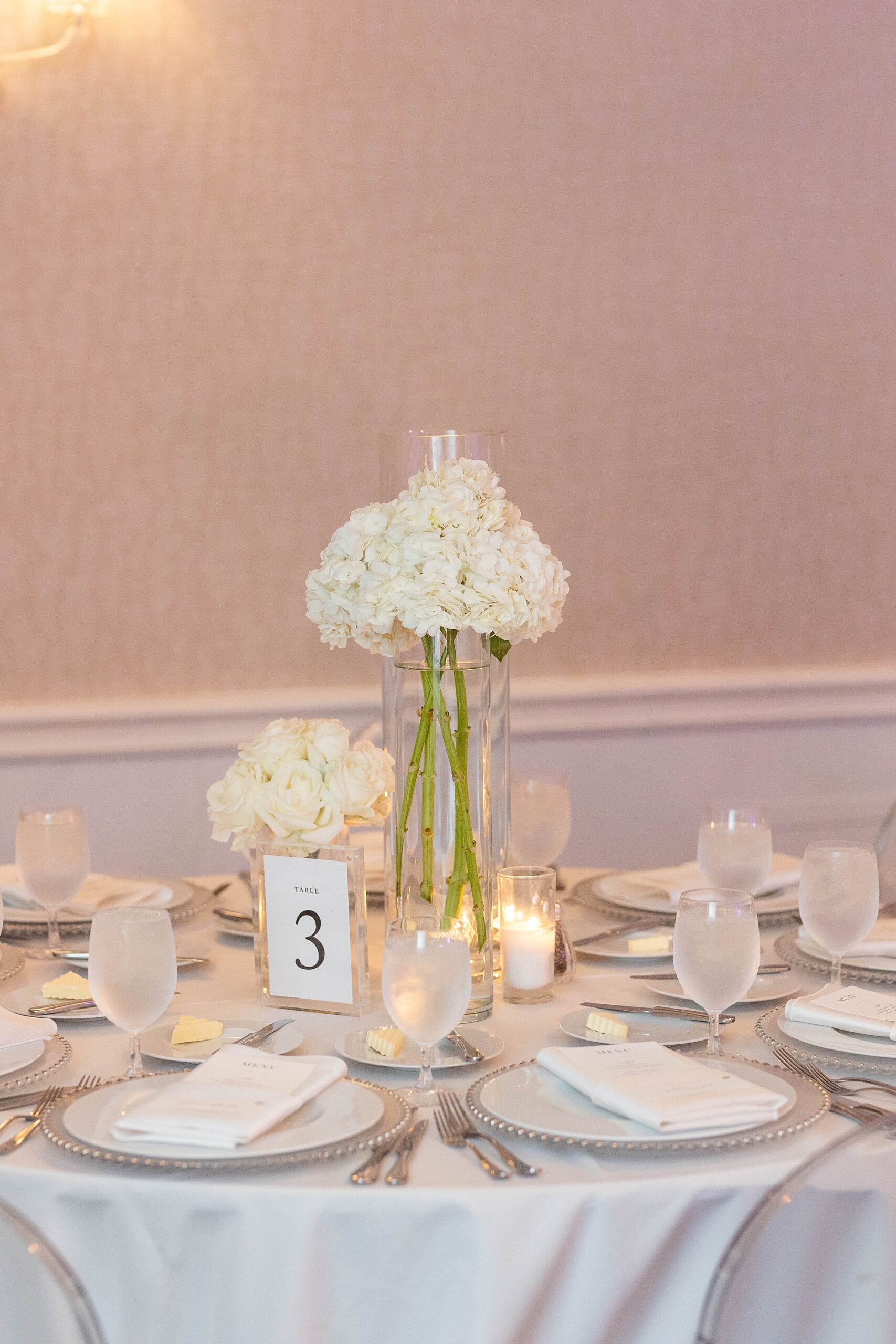 wedding reception centerpiece with white flowers and silver accents 