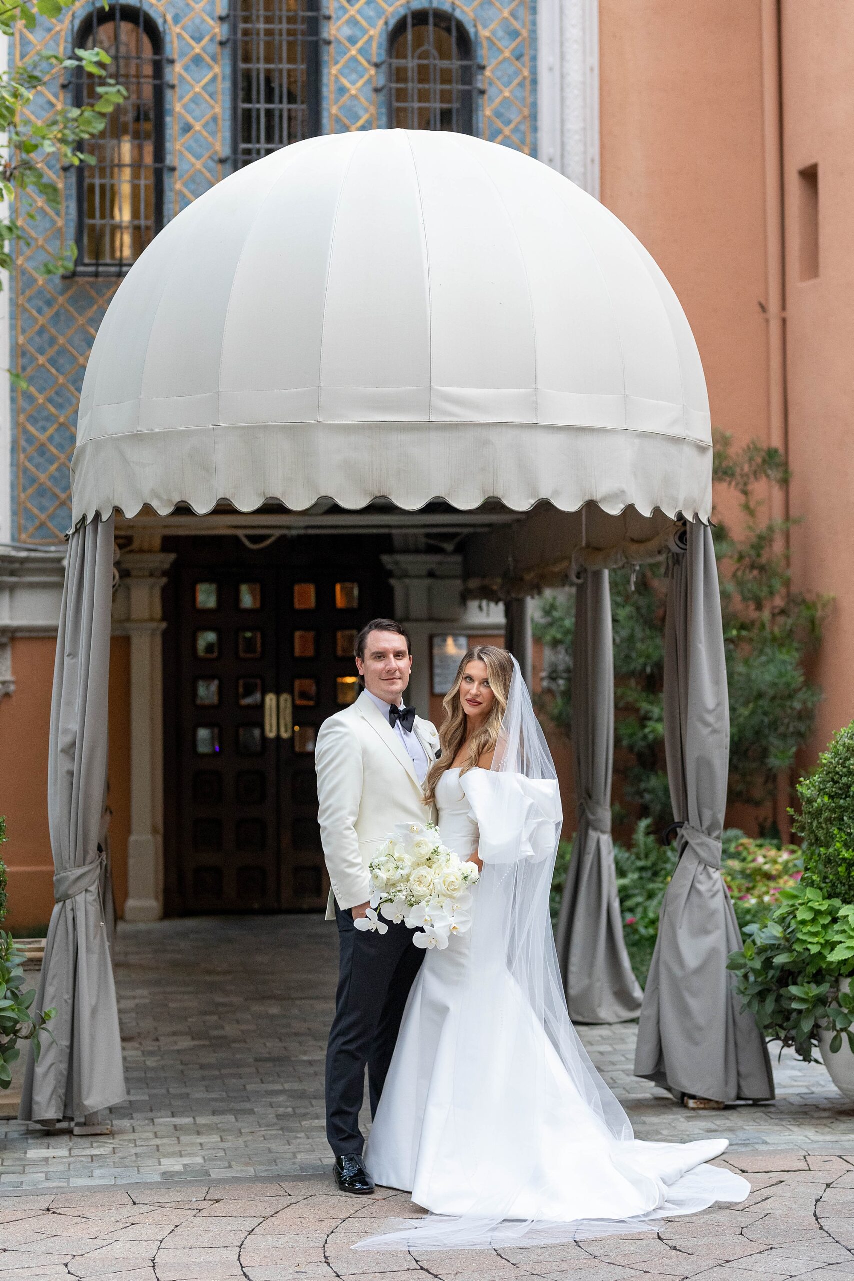 bride and groom stand under 1920's awning at Rosewood Mansion
