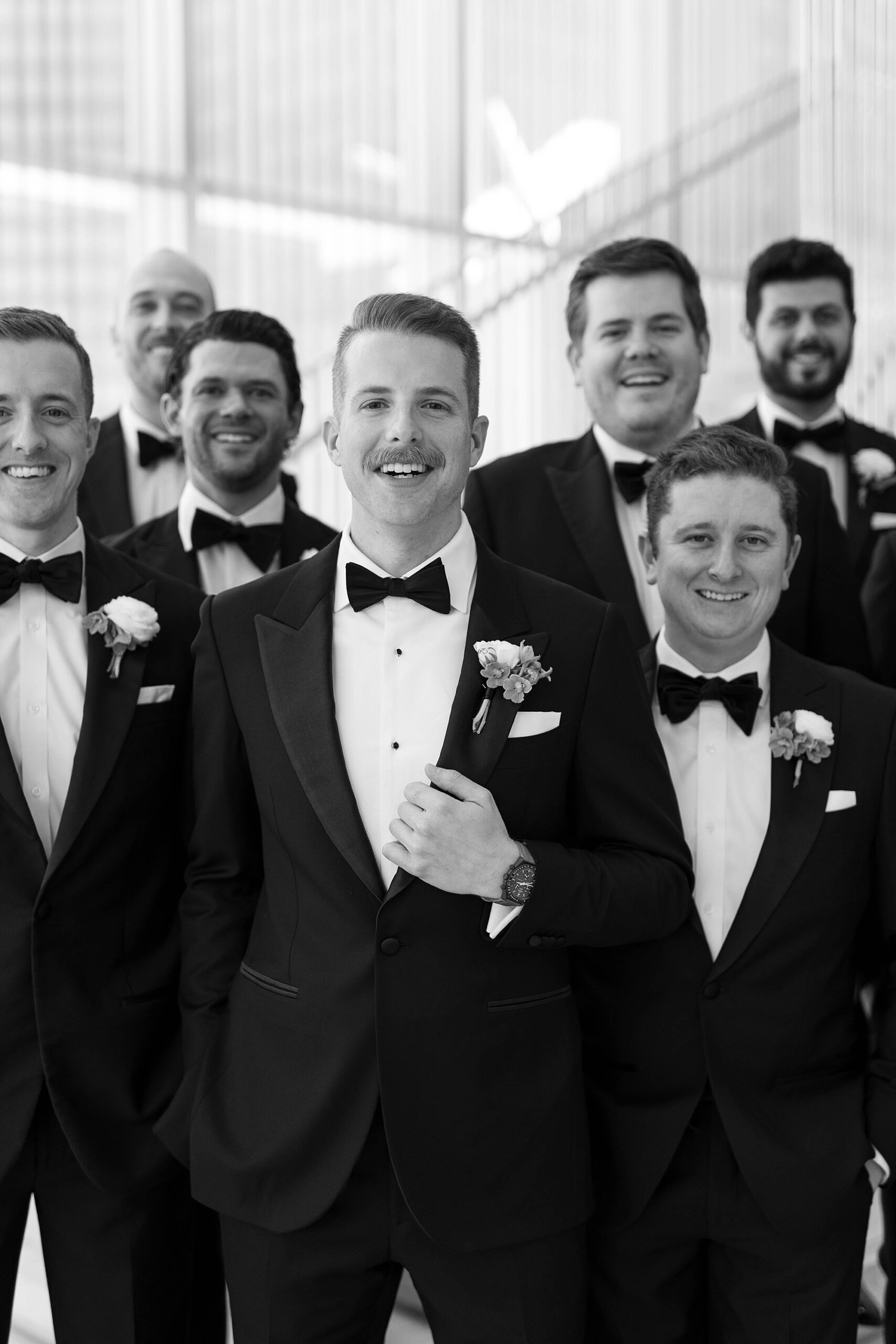 groom stand with groomsmen around him in black suits in Dallas TX