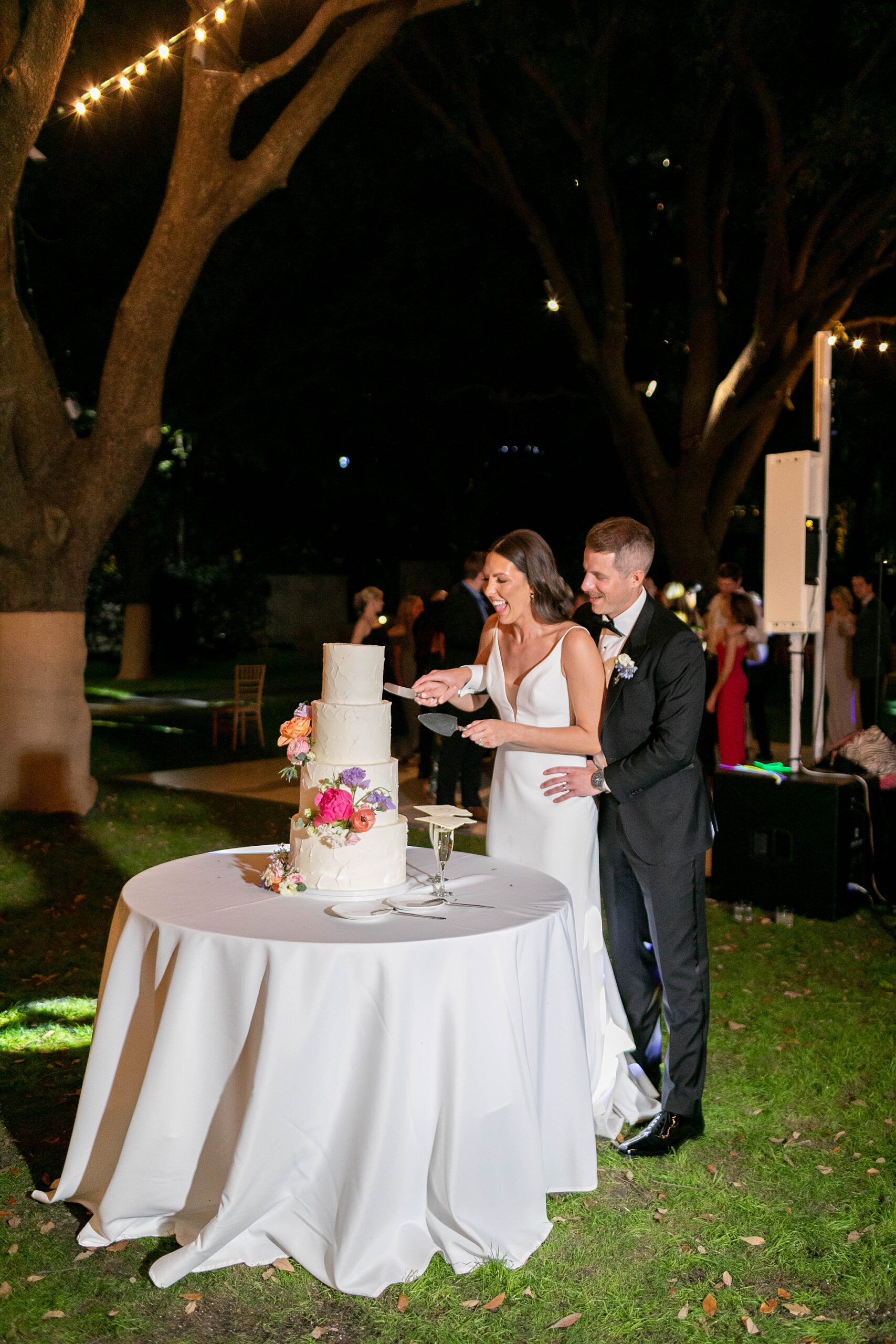 bride and groom cut cake during al fresco wedding reception at the Nasher Sculpture Center
