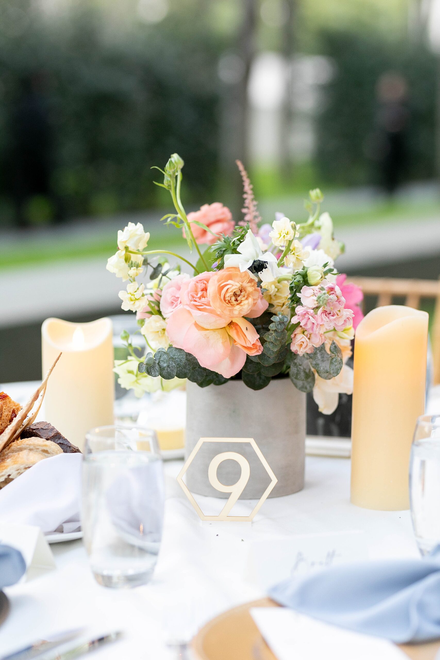 table centerpiece with pink and orange flowers and candles 