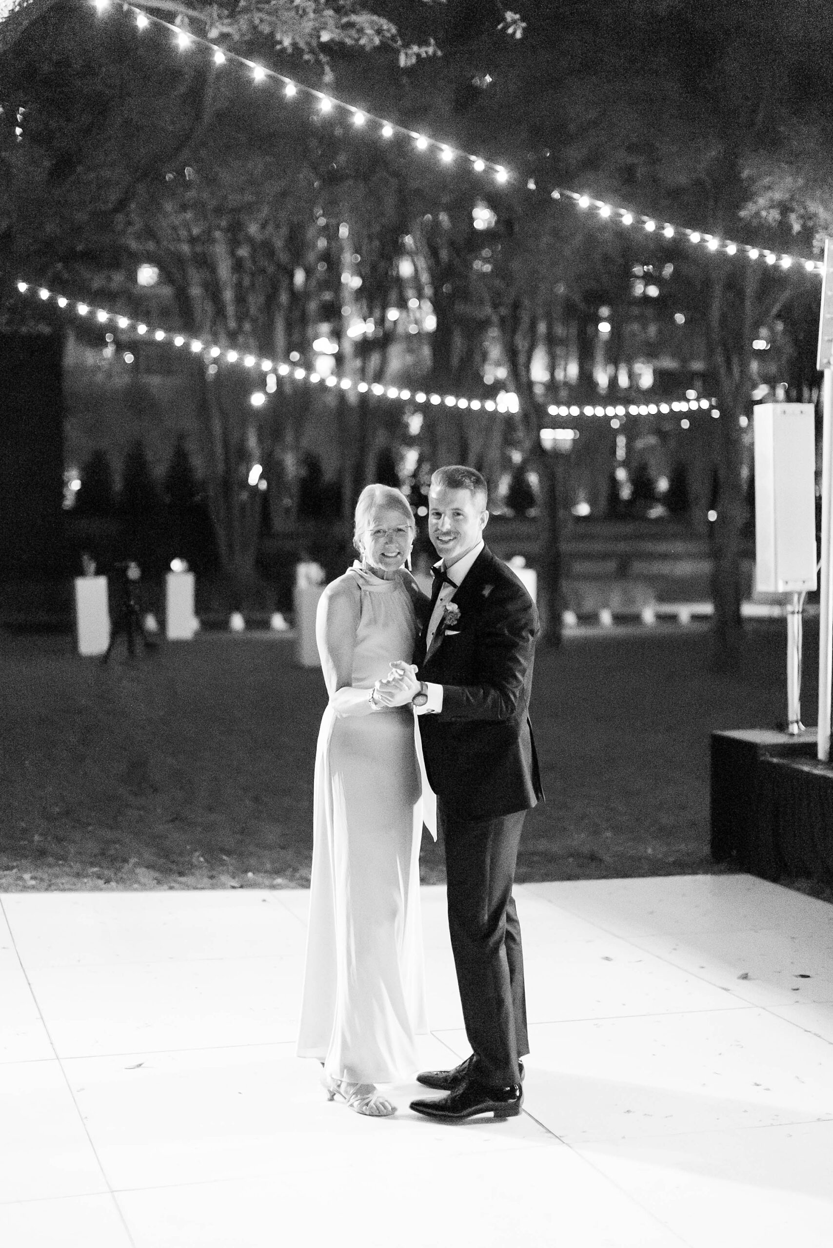 groom and mother hug on dance floor during outdoor Dallas wedding reception 
