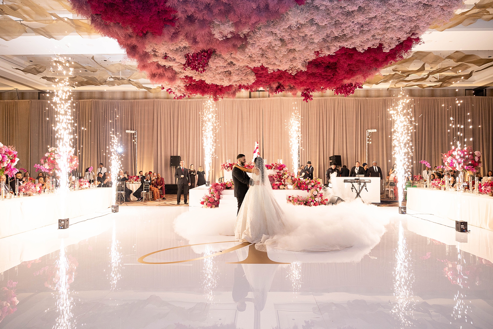newlyweds dance in ballroom on custom gold and white floor 