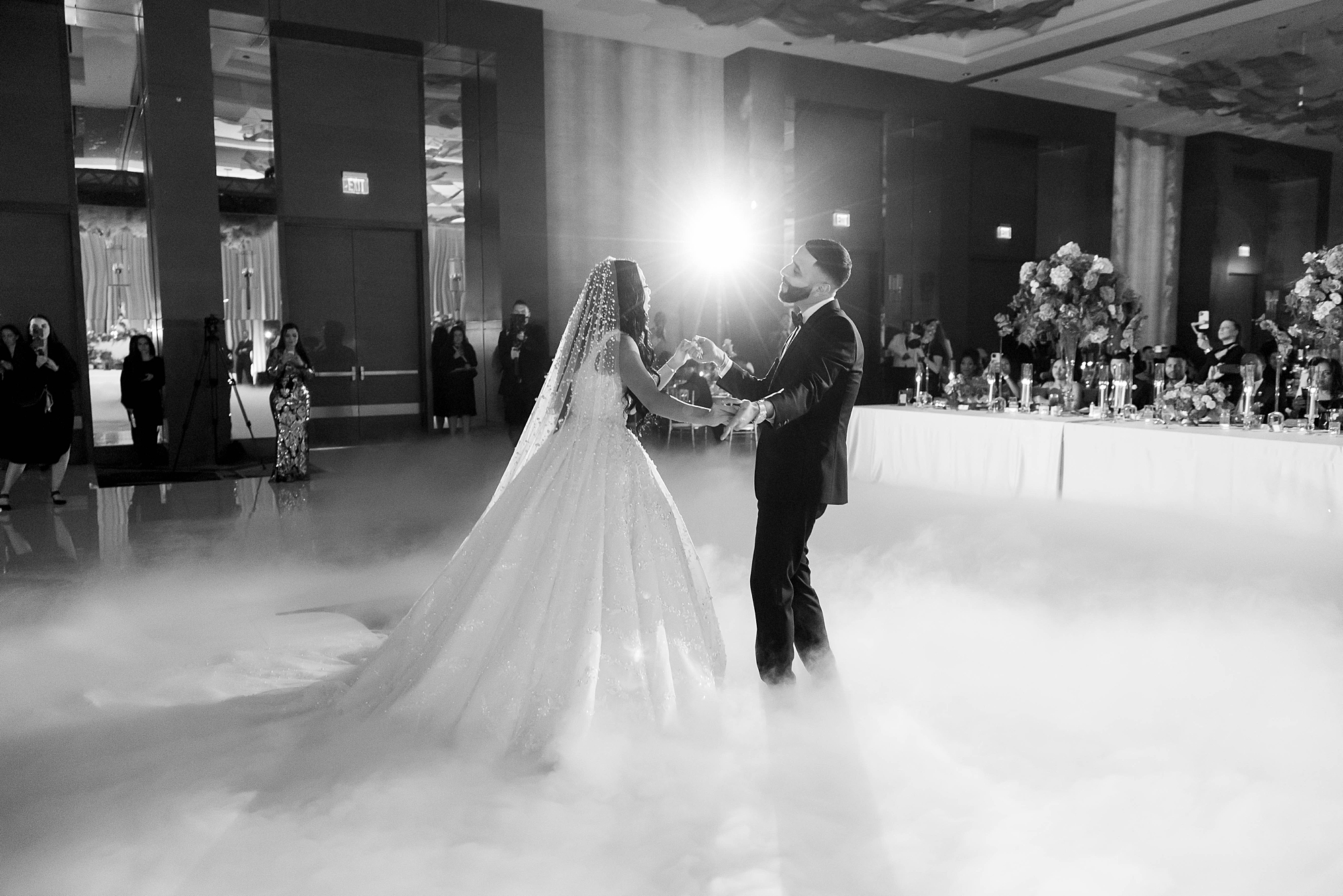 bride and groom hold hands as fog moves around them on dance floor at the Omni Frisco at the Star