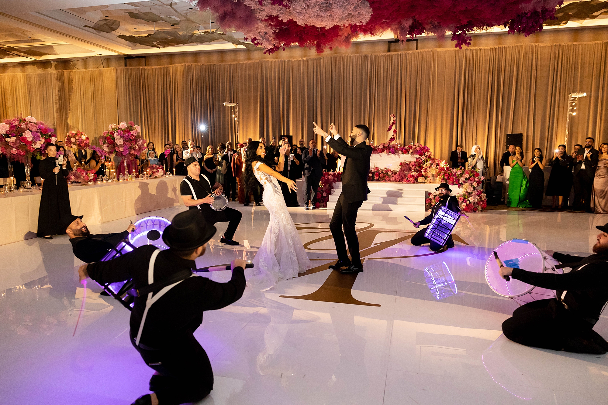 newlyweds dance with band and performers around them 