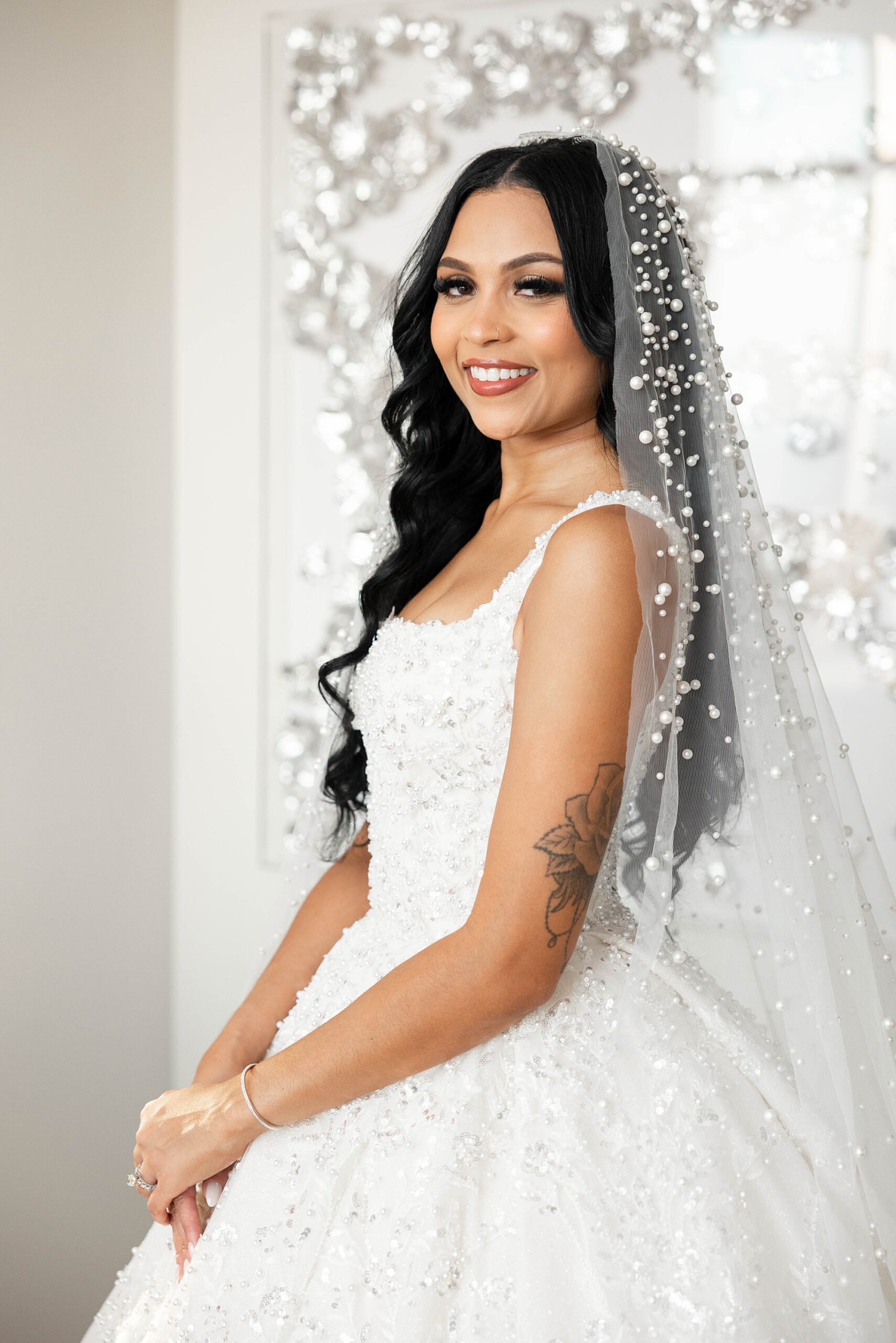 bride stands with sparkly veil around her shoulders