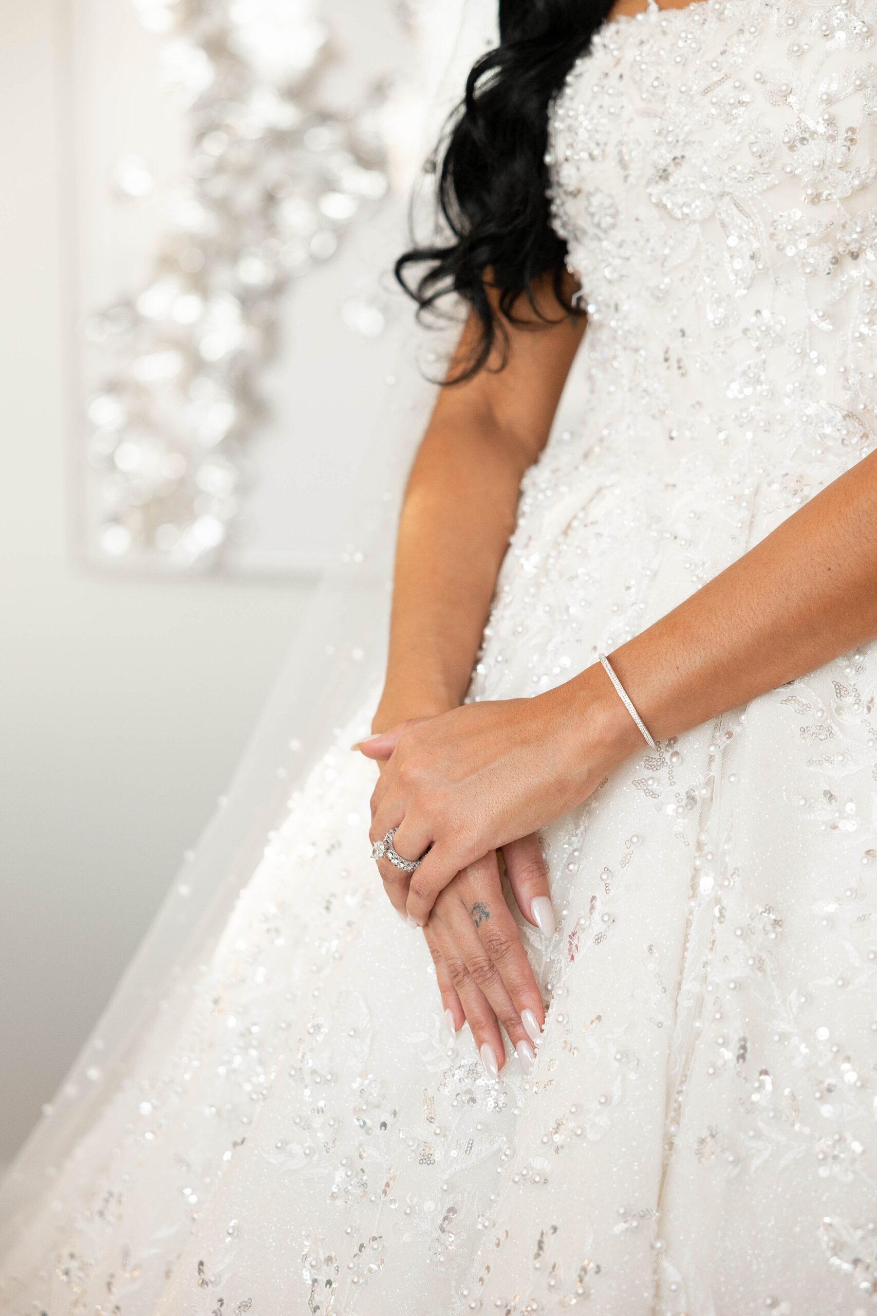 bride holds hands in front of her ballgown wedding dress 